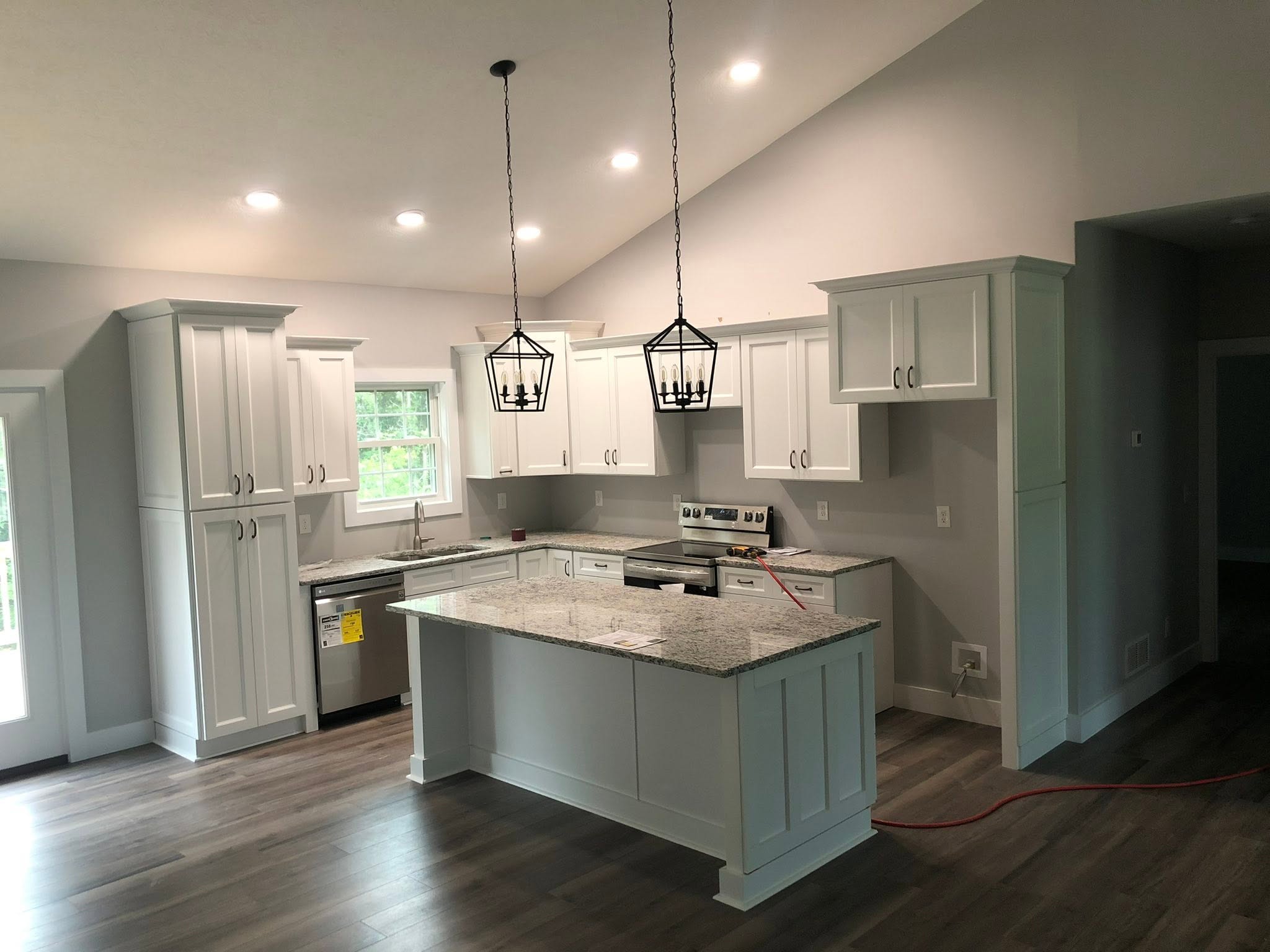 White shaker kitchen with granite island and black pendant lights